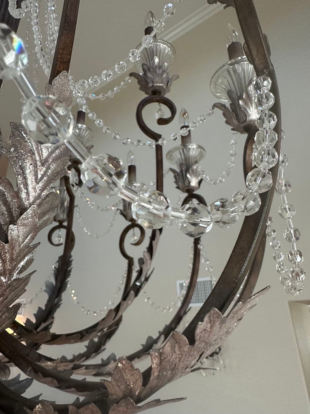 Elegant chandelier with crystal beads and intricate metalwork, enhancing interior decor.